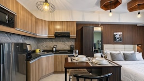 Una cucina moderna con forno integrato, macchina del caffè e zona pranzo con tavolo imbandito per due persone.