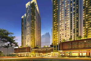 A high-rise hotel with multiple floors, a covered entrance, and a modern architectural design. - Evergreen Haven Studio | Prime IT Park Spot (Cebu City)