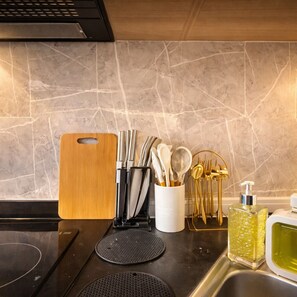 A kitchen counter with a cutting board, knives, spoons, and a bottle of dish soap. - Japandi Twin Studio in Cebu IT Park (Cebu City)