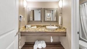 A bathroom with a marble countertop, two mirrors, a sink, a towel rack, and a shower curtain. - Relaxing 1 bedroom oceanfront. (Myrtle Beach)