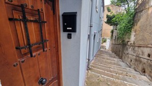 A narrow alleyway with a wooden door and a mailbox on the wall. - old town experience like no other (Gibraltar)