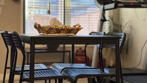 A dining area with a table, chairs, and a basket of bread. - Family friendly, super clean & Cozy Walkout basement suite with all amentities (Calgary)