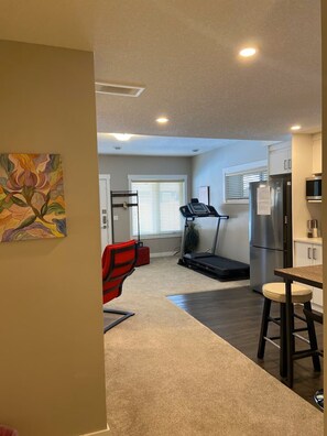 A compact kitchen with a treadmill, a refrigerator, and a dining area. - Family friendly, super clean & Cozy Walkout basement suite with all amentities (Calgary)