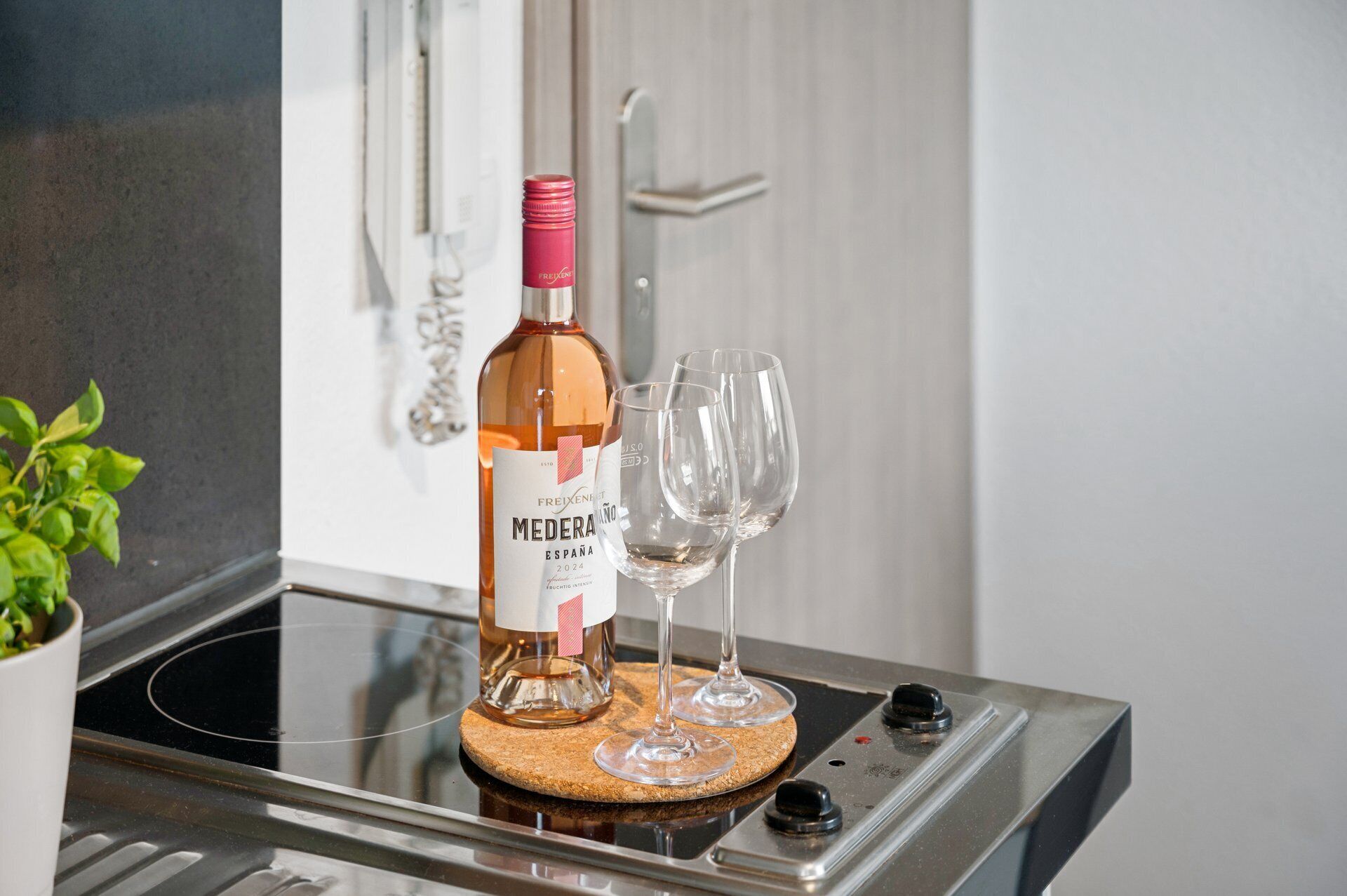 En flaska Freixenet Mederaño-vin och två glas på en köksbänk.