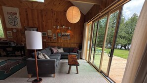 Een gezellige woonkamer met een bank, een lamp en uitzicht op de omgeving.