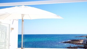 A balcony with a white umbrella overlooking a coastal view. - Magnificent seaside residence with a 50 m² rooftop terrace and 2 large balconies (Villanova)