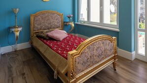 Ein Schlafzimmer mit einem Bett, einem Fenster und einem an der Wand befestigten Spiegel.