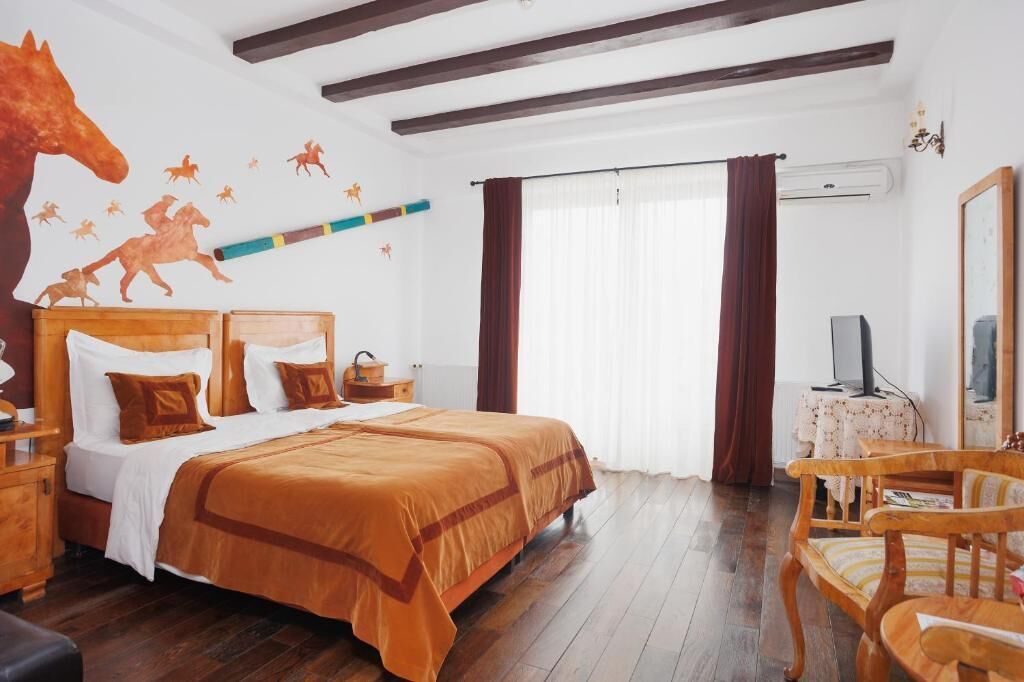 Una camera da letto con un grande letto, una testiera in legno e una decorazione a tema cavallo.