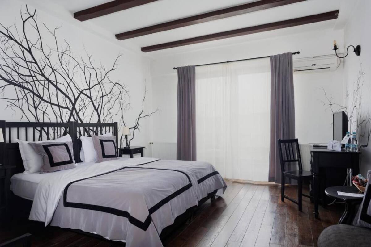 A bedroom with a large bed, a desk, and a chair.