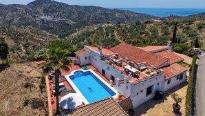 Una villa con piscina, jardines escalonados y vistas al mar.