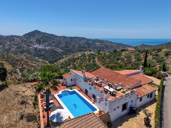 Eine Villa mit Swimmingpool, angelegten Terrassengärten und Meerblick.