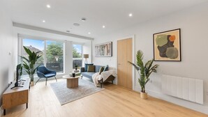 Un salon moderne avec un canapé, une table basse et des plantes.