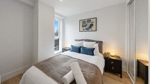 Una camera da letto moderna con un letto grande, un comodino e una finestra.