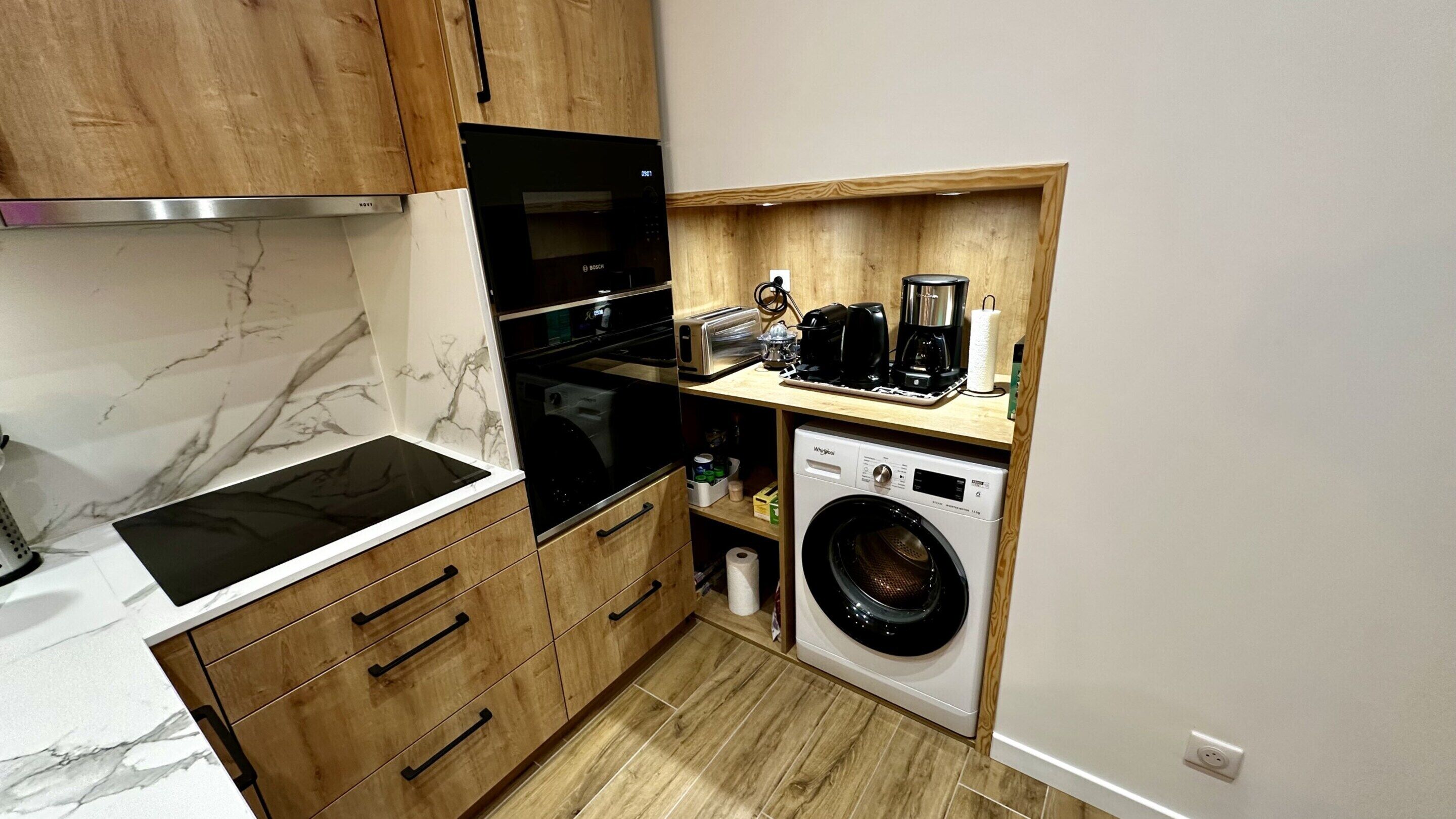 Cocina compacta con horno integrado, microondas, tostadora y lavadora.