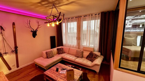 Un salon avec un canapé, une table basse en bois et un porte-skis.