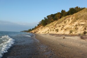 A beach with a sandy shore and a grassy cliff. - Lake Retreat - Sleeps 18 - Beach & Lake Access (South Haven)