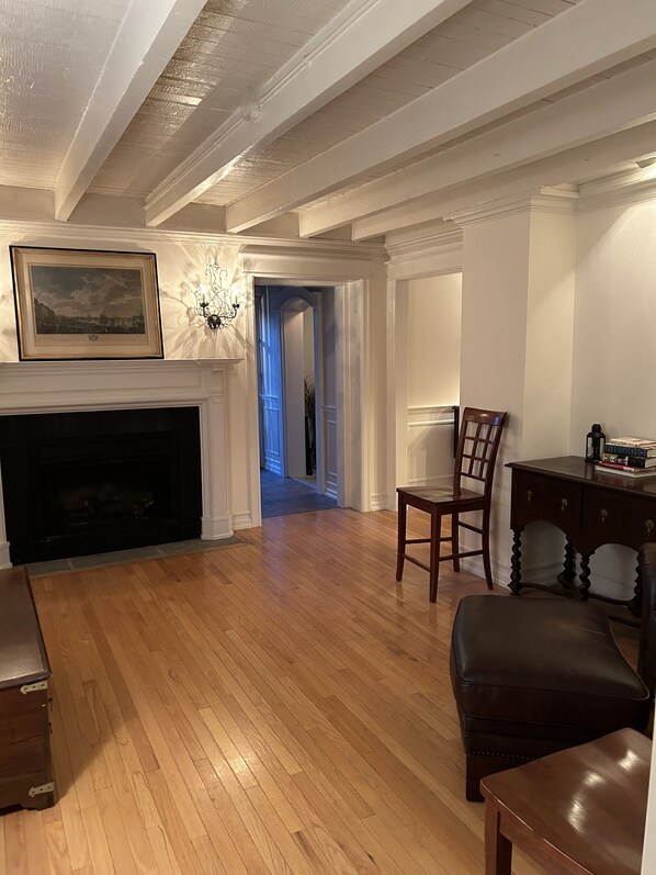 A spacious living room with hardwood flooring, a fireplace, a dining area with a table and chairs, and a hallway leading to another room. - ENTIRE HOME - PGA EVENTS/WORLD CUP EVENTS - WITHIN MINUTES AWAY (HAVERFORD)