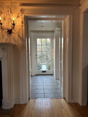 A hallway with a view to a large window, a fireplace, and a chandelier. - ENTIRE HOME - PGA EVENTS/WORLD CUP EVENTS - WITHIN MINUTES AWAY (HAVERFORD)