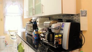 Una cocina equipada con cafetera, microondas y diversos electrodomésticos.
