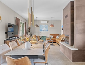 A modern living room with a dining area, featuring a large table, sofas, and a TV. - Elegant Family Retreat With Pool in Istria (Zminj)