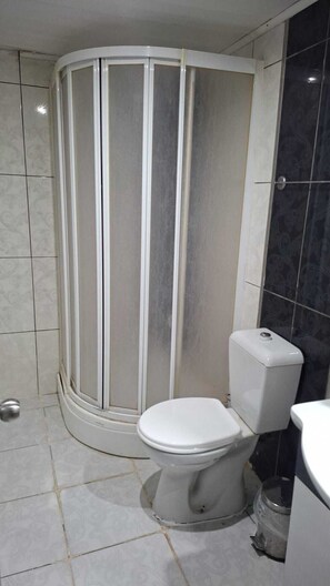 Habitación doble económica, vista a la colina | Baño | Regadera, toallas, shampoo, papel de baño 