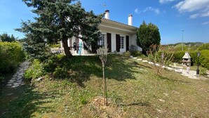 Ein Haus mit Garten, einem Weg und blauem Himmel.