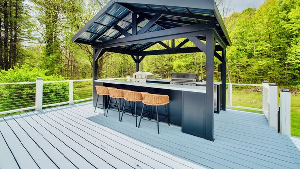 A deck with a black gazebo, a bar area, and three wicker bar stools. - Stream Home (Saratoga Springs)