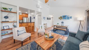 A modern living room with a sofa, a coffee table, and a dining area. - Sleeps 12! Ocean Views! 4 BD/4BA! 2 Renovated Condos! (Kihei)