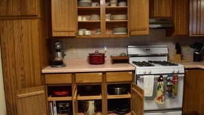 A kitchen with wooden cabinets, a stove, and various kitchen appliances.