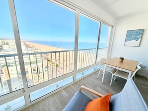 Un balcón con vista a la playa y al paisaje urbano.