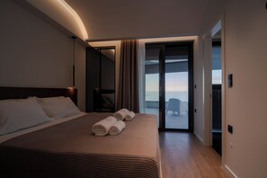 Ein Hotelzimmer mit Bett, Blick durch eine Glastür und einem Balkon.