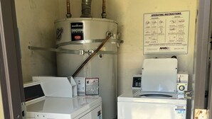 Una sala amb rentadora, assecadora i acumulador d'aigua.