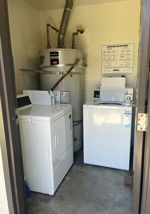 A laundry room with a washer, dryer, and water heater. - Light Bright Condo (Duarte)