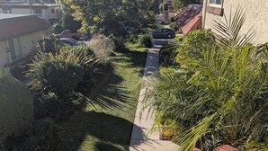 Zona residencial amb un camí pavimentat, una escala i diferents plantes.