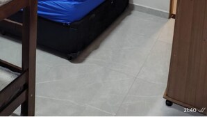 Ein kleines Zimmer mit Etagenbett, Schreibtisch und einem an der Wand befestigten Fernseher.