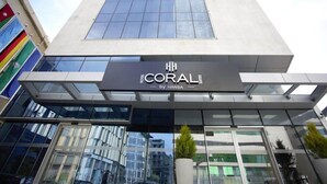 Ein modernes Hotelgebäude mit Glasfassade und einem Schild mit der Aufschrift "CORAL by Hansa".
