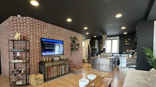 A modern living room with a brick accent wall, a wooden coffee table, and a sofa. - Beautiful atypical loft with Jacuzzi (Tarascon)