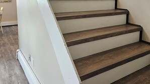 Un escalier avec des marches en bois et des murs blancs.