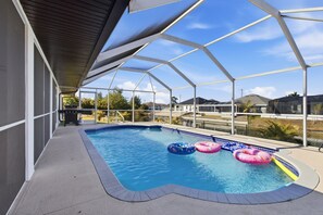 Une piscine couverte avec des bouées gonflables, entourée d’une structure métallique et d’un espace patio.