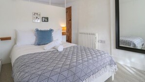 Un dormitorio con una cama, un espejo grande y un radiador.
