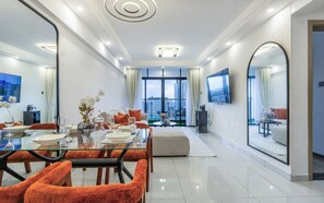 A modern living room with a dining area, large windows, and a TV. - Riara one residency (Nairobi)