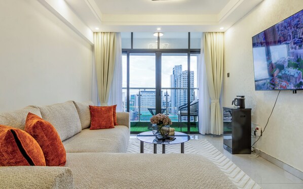 Ein modernes Wohnzimmer mit einer Couch, einem Couchtisch und einem großen Fenster mit Blick auf die Stadt.
