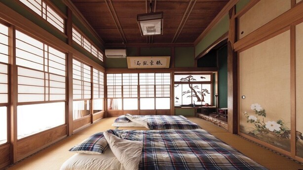 Ein traditioneller japanischer Raum mit Tatami-Böden, Shoji-Schirmen und einem Futon.
