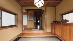 Ein traditionelles japanisches Interieur mit Holzboden, Tatami-Matten und einer Schiebetür.