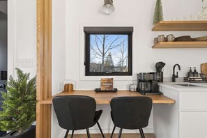 A modern kitchen with a built-in window, a coffee machine, and a small potted plant. - Evergreen Cabin Ocean Front Acadia A Frame Studio (Tremont)