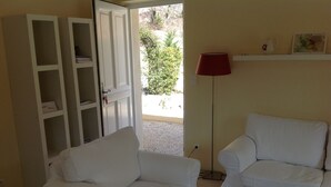 Una habitación con dos sillas blancas, un armario cerrado y una lámpara de pie.
