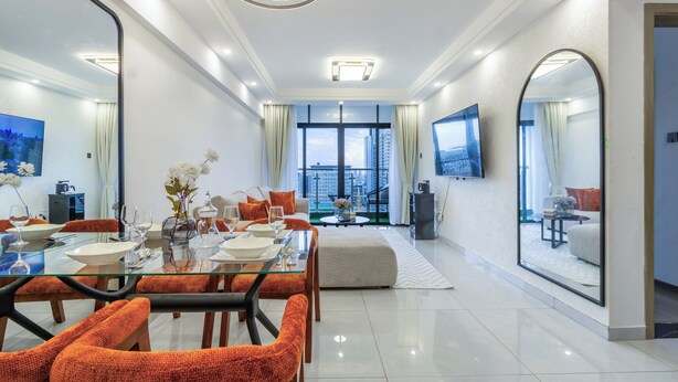 A modern living room with a dining area, large windows, and a TV. - Shangrila Residency  (Nairobi)