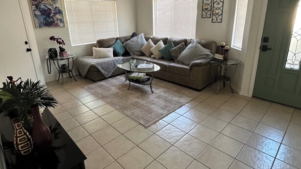A living room with a ceiling fan, a sofa set, a coffee table, and a small side table.