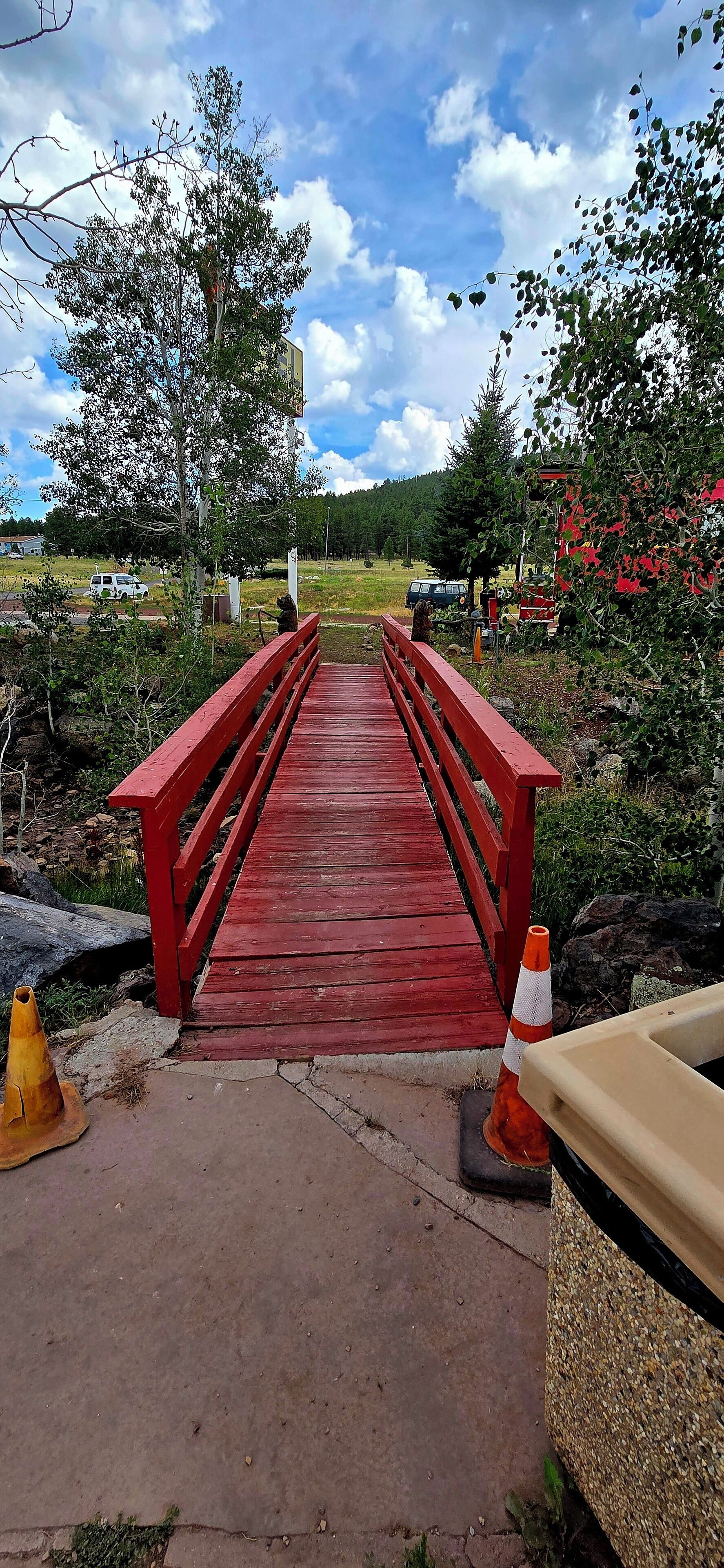 Un puente de madera rojo que conduce a un edificio con techo rojo.