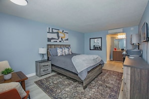A bedroom with a bed, bedside table, lamp, and a dresser. - Mins to Uptown*Hospitals*Stadiums*Arenas & Museums (Charlotte)
